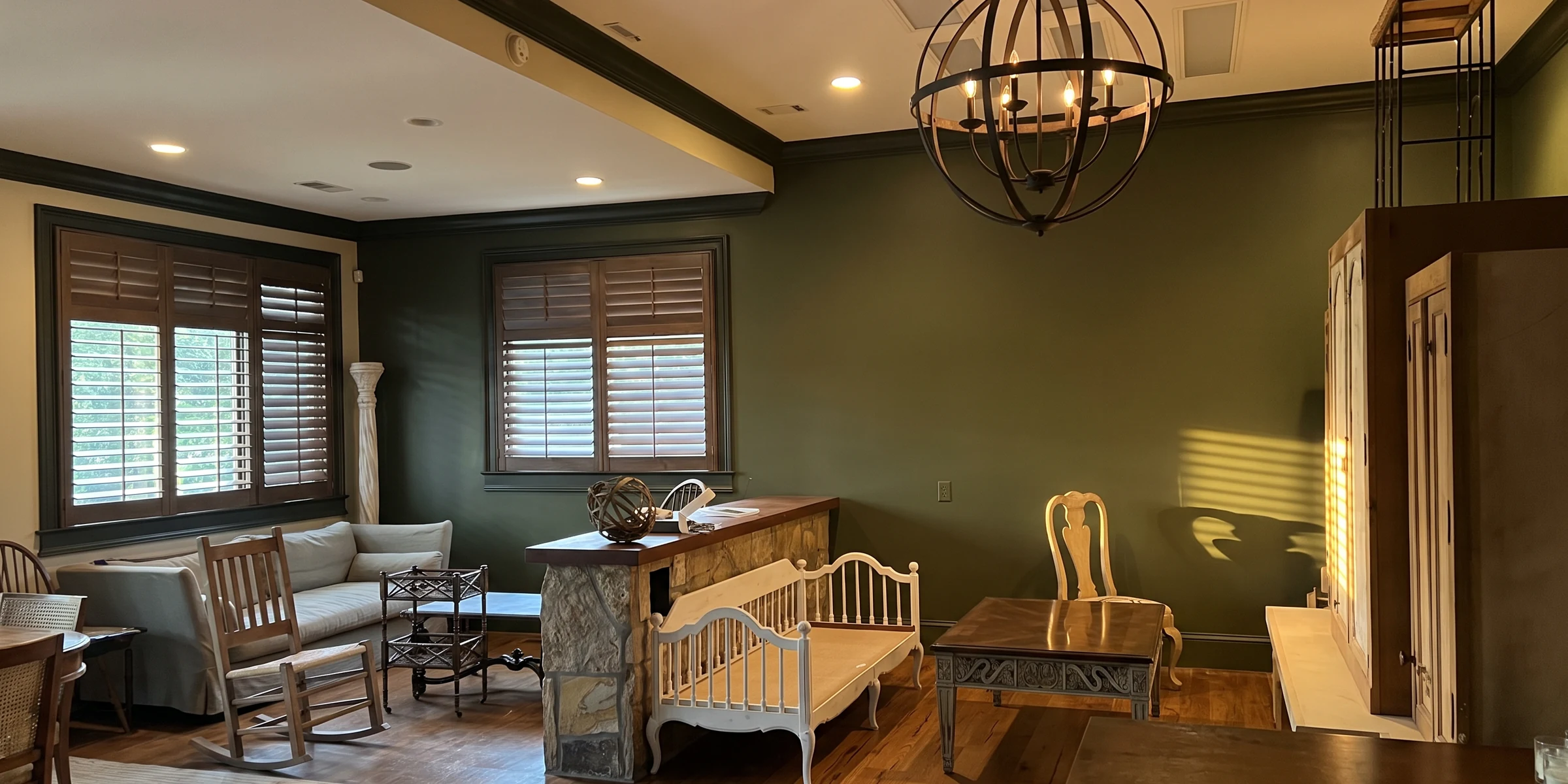 A finished living room with deep olive-green walls, a cream ceiling and the furniture back in place
