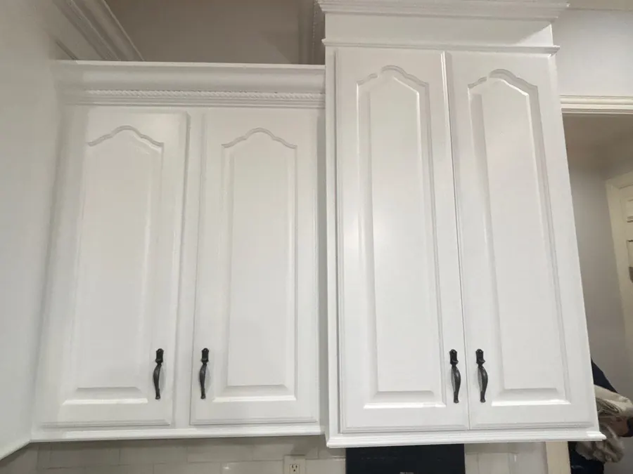 Refinished white raised-panel cabinet doors with black hardware