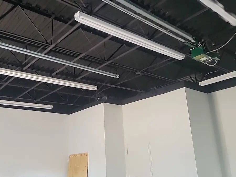 A warehouse interior with the exposed roof deck painted dark