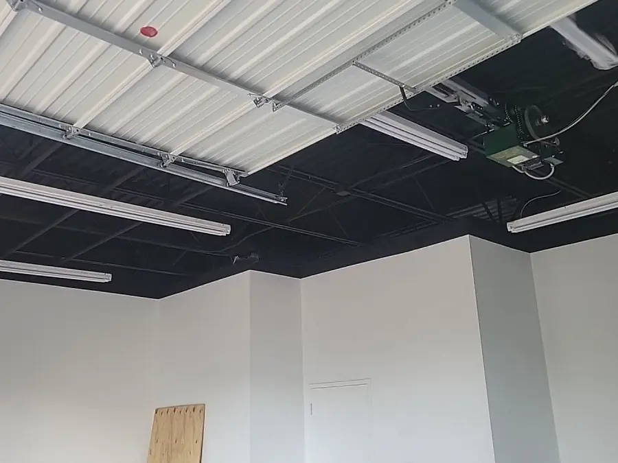 Commercial interior painting: white walls under a dark painted deck