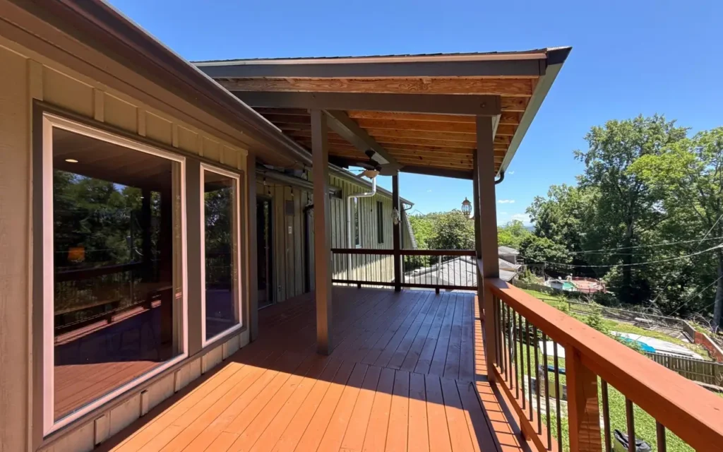A stained deck with railings overlooking trees in Chattanooga