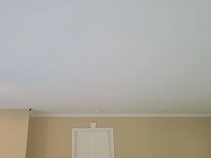 The finished smooth ceiling above the same tan walls