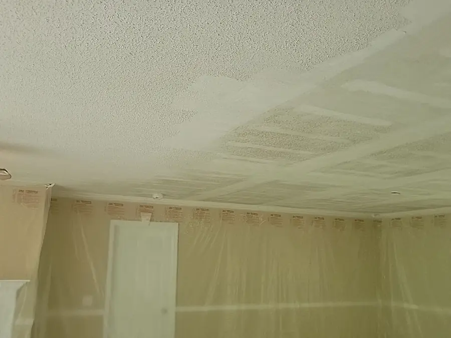 A textured popcorn ceiling above tan walls