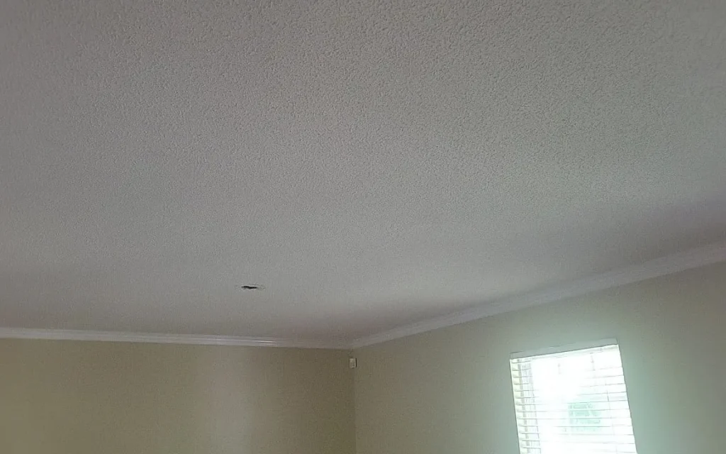 A smooth ceiling after popcorn ceiling removal, finished with crown molding