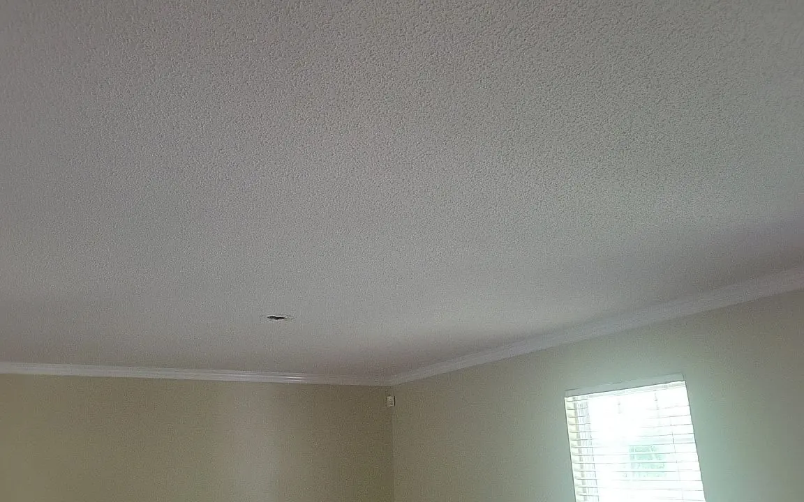 A smooth ceiling after popcorn ceiling removal, finished with crown molding