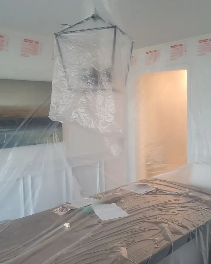 A room sealed with plastic sheeting from floor to ceiling before work begins