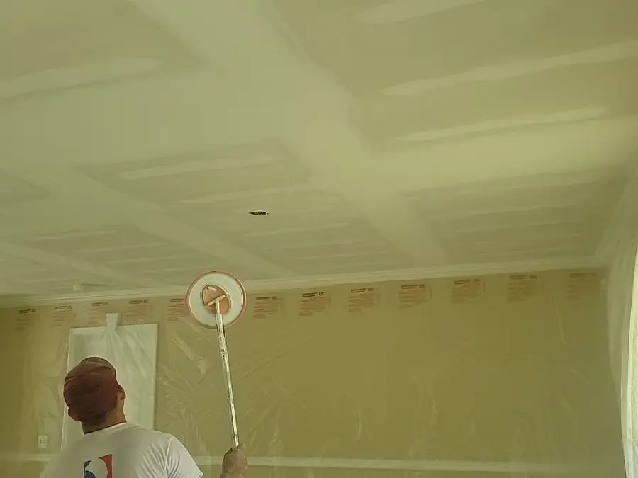 A painter rolling a finished ceiling