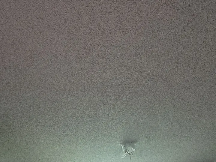 A close view of a textured popcorn ceiling before removal