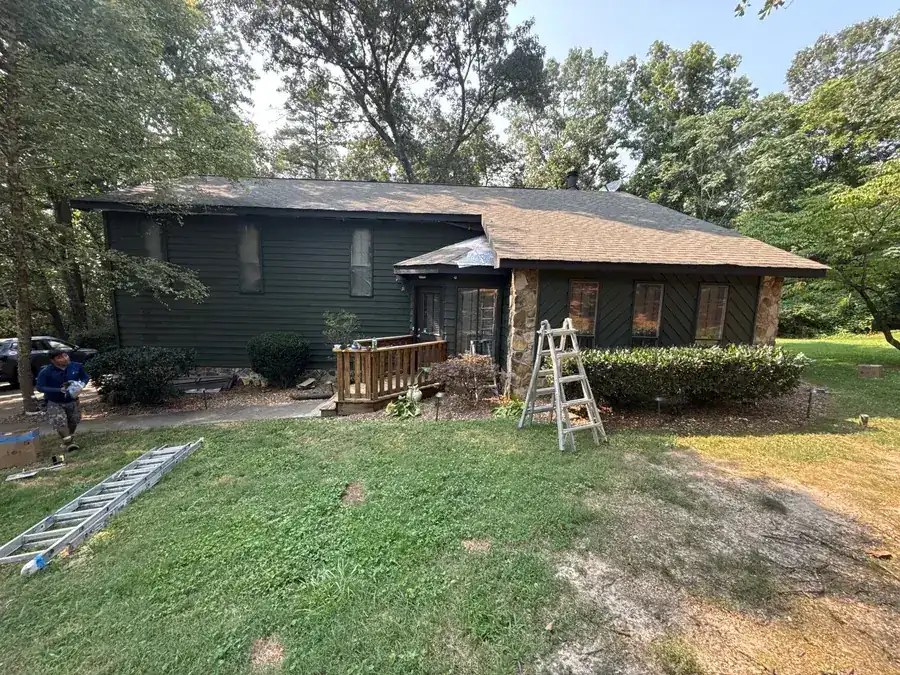 An exterior repaint in progress with ladders against the house