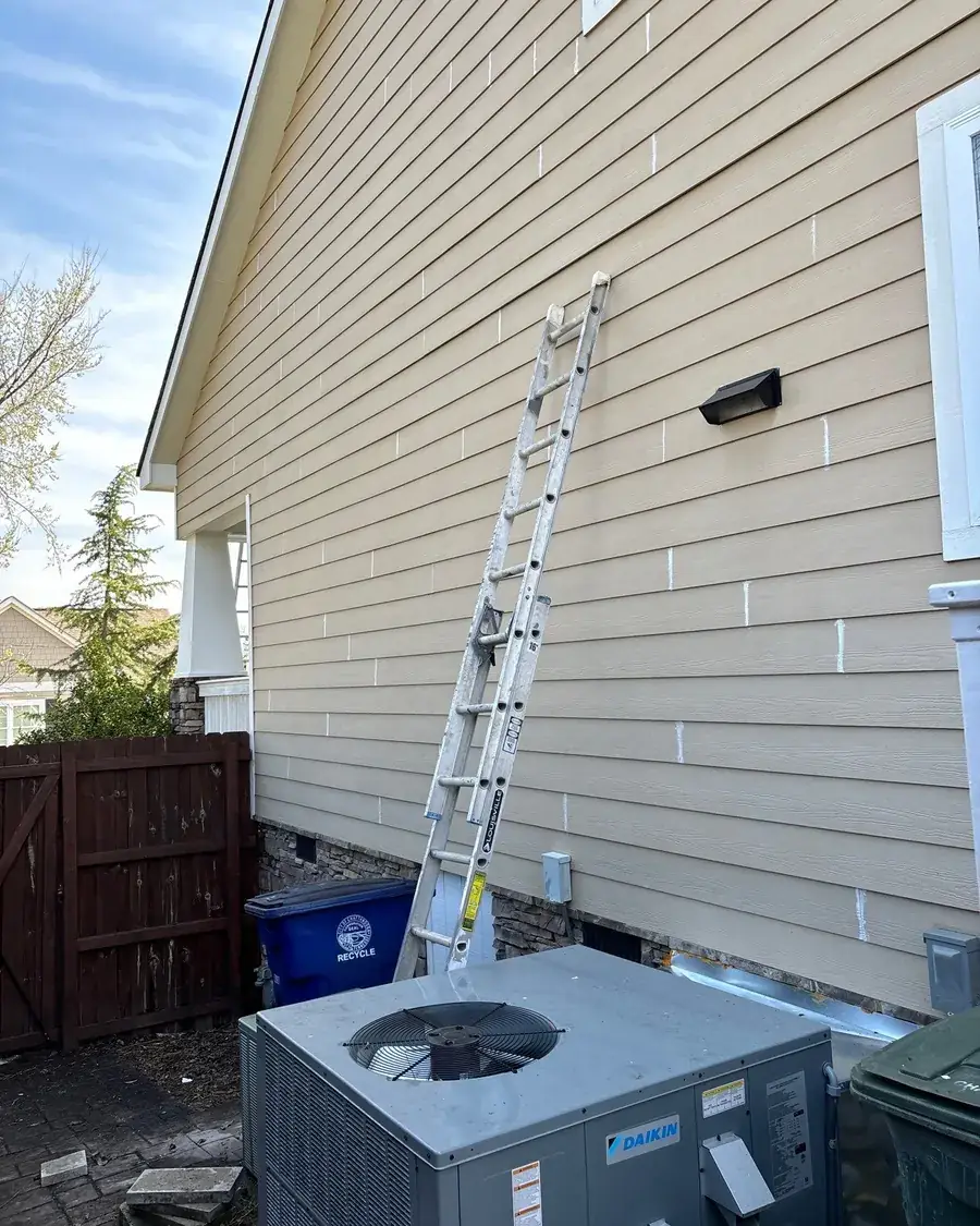 Ladders set against a house before exterior painting begins