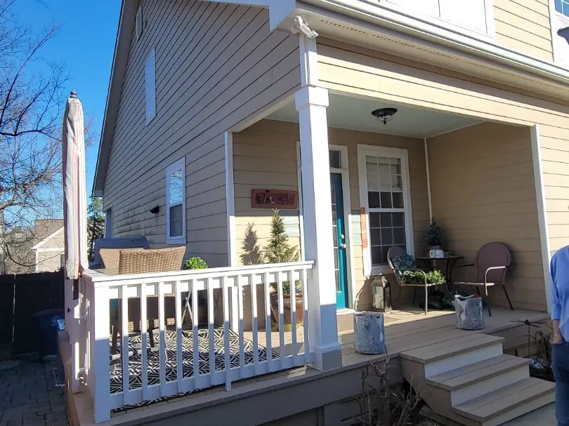 A repainted porch with white columns and railing