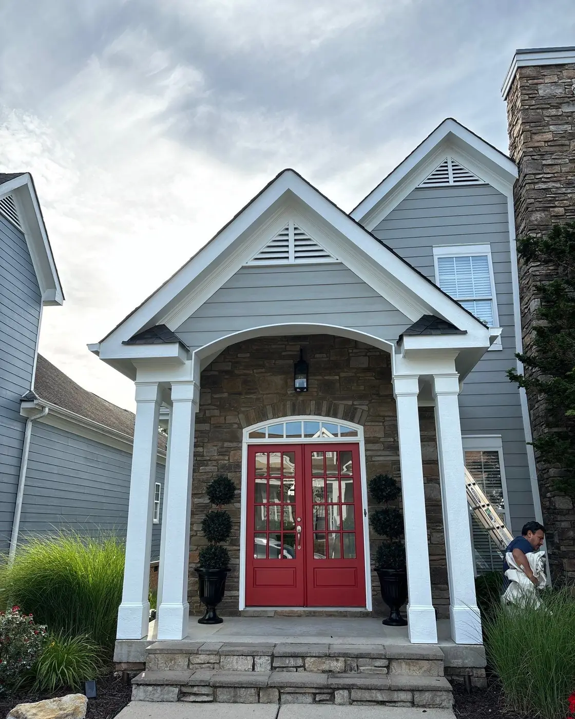 Residential painting in Ooltewah: a repainted home exterior with white columns and a red front door